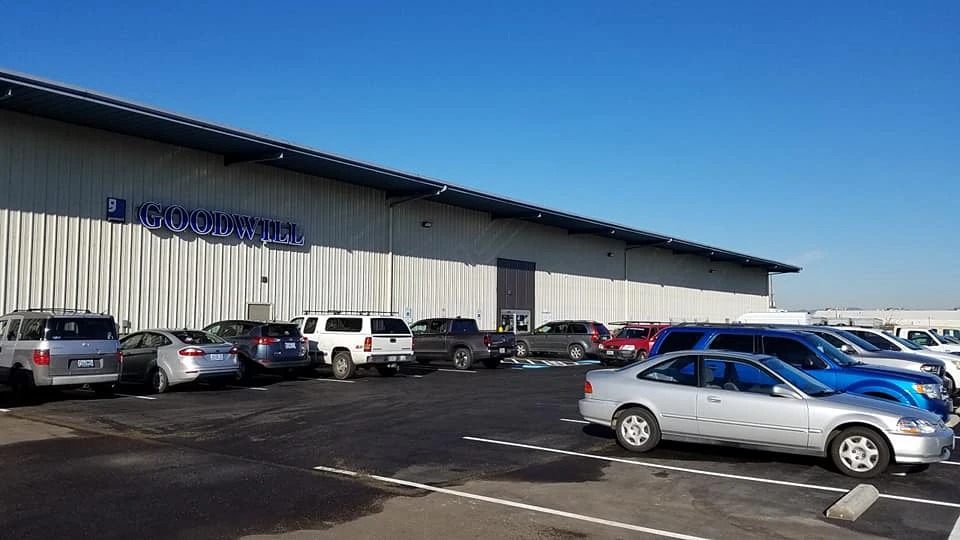 Goodwill As-Is Outlet and Donation Center in Medford, Oregon, showing blue rolling bins filled with discounted merchandise.