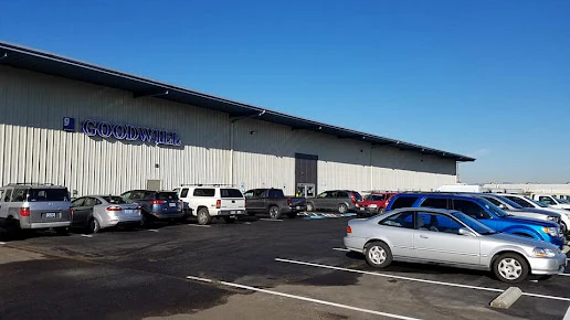 Goodwill As-Is Outlet and Donation Center in Medford, Oregon, displaying a large open layout with rows of donation bins.