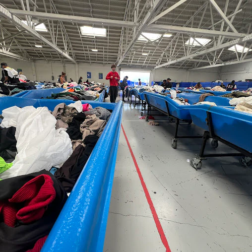 Goodwill Auction & Outlet Store in Long Beach, California, highlighting organized racks of clothing near the checkout area.