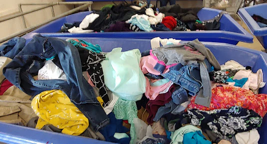 Goodwill Gulf Coast - Airport Bargain Store in Mobile, Alabama, featuring shoppers searching through bulk textile containers.