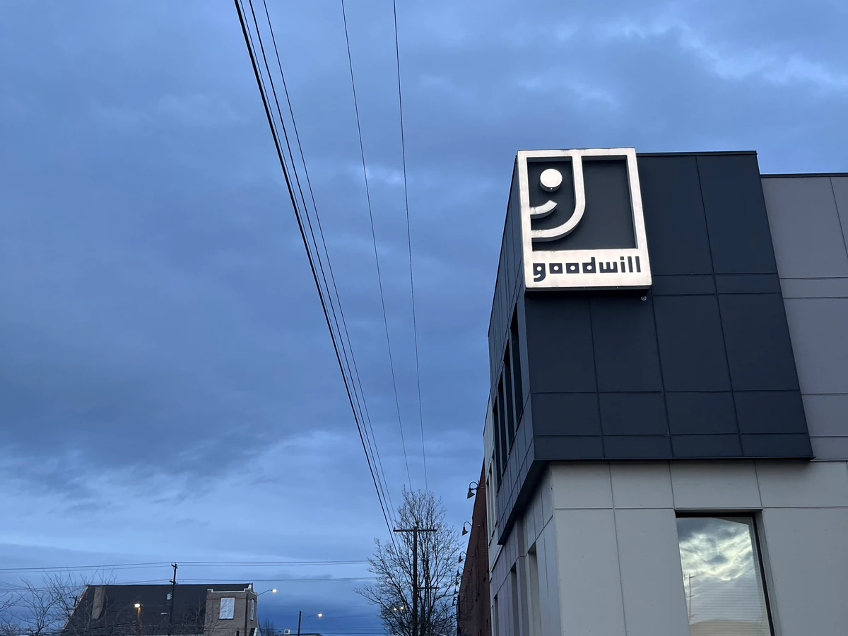 Goodwill Industries Outlet Store in Spokane, Washington, featuring shoppers searching through bulk textile containers.