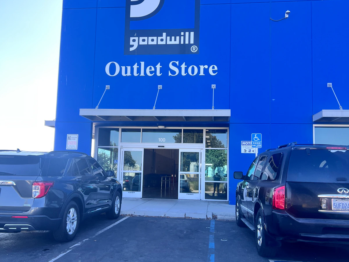 Goodwill Industries San Joaquin Outlet in Stockton, California, showing blue rolling bins filled with discounted merchandise.
