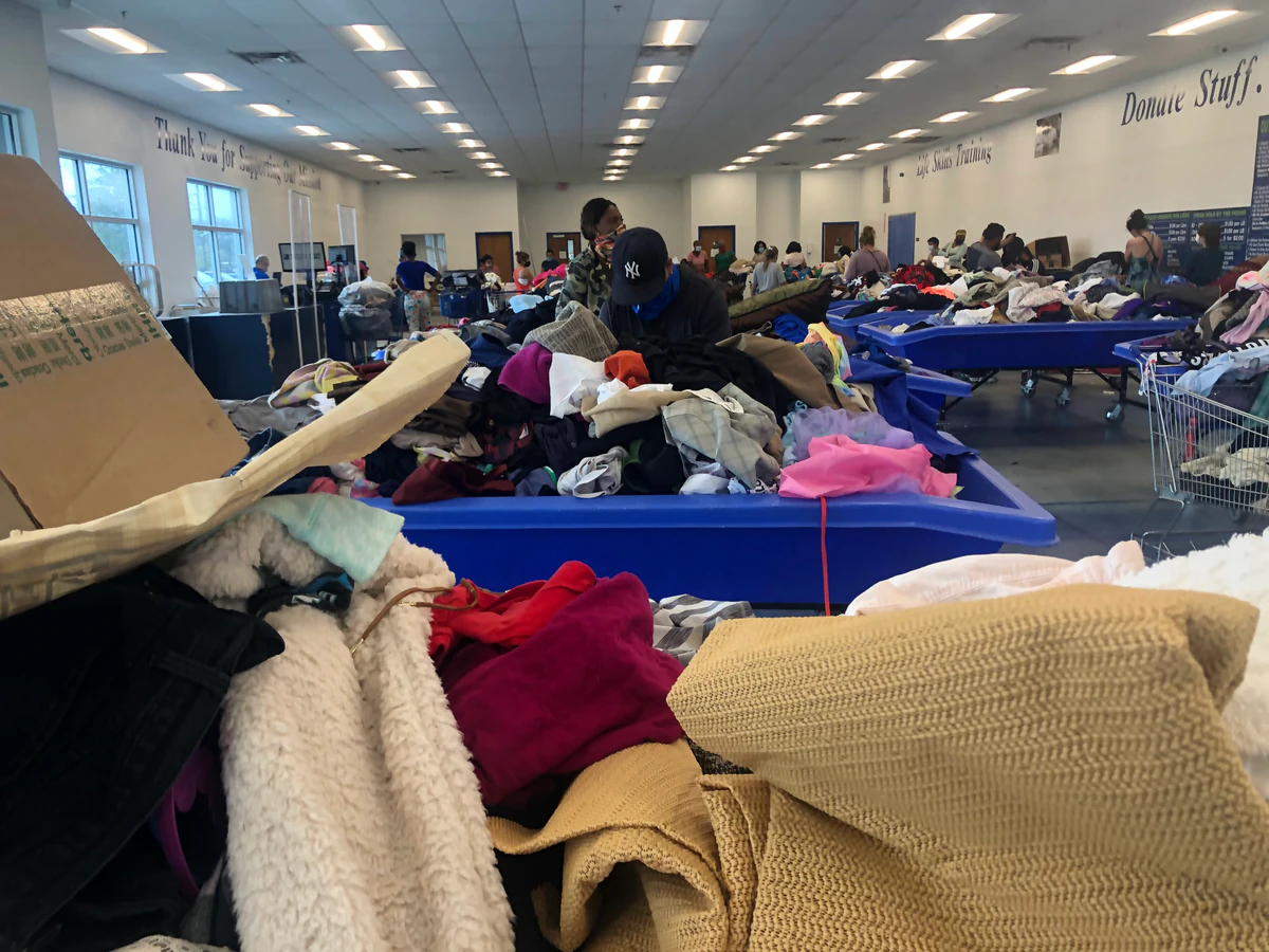 Goodwill Lake Worth Bargain Barn in Lake Worth Beach, Florida, featuring shoppers searching through bulk textile containers.