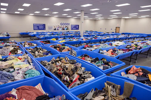 Goodwill Madison Outlet Store in Madison, Wisconsin, featuring shoppers searching through bulk textile containers.