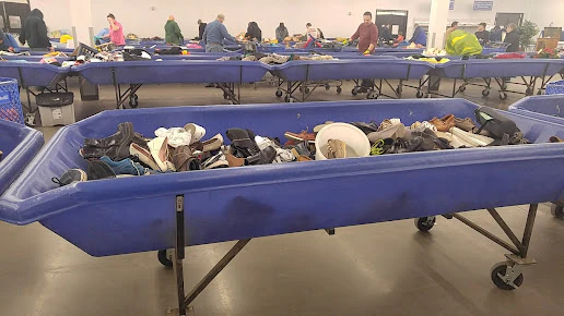 Goodwill NCW Outlet Store in Appleton, Wisconsin, highlighting organized racks of clothing near the checkout area.