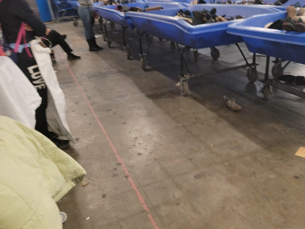 Goodwill NYNJ Outlet Store & Donation Center, a Goodwill outlet store featuring shoppers searching through bulk textile cont.