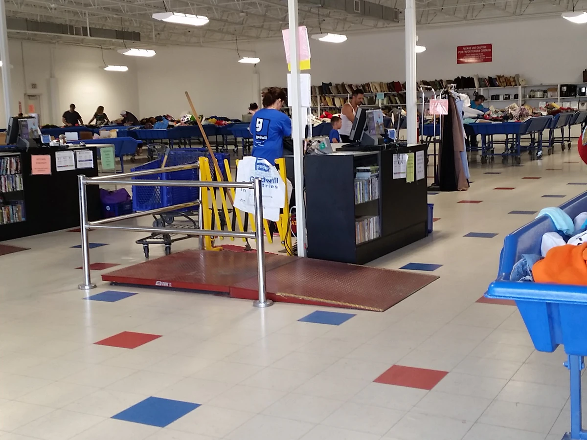 Goodwill of Central Iowa - Outlet in Des Moines, Iowa, featuring shoppers searching through bulk textile containers.