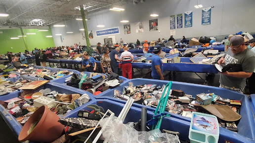Goodwill Outlet and Donation Center, a Goodwill outlet store featuring shoppers searching through bulk textile containers..