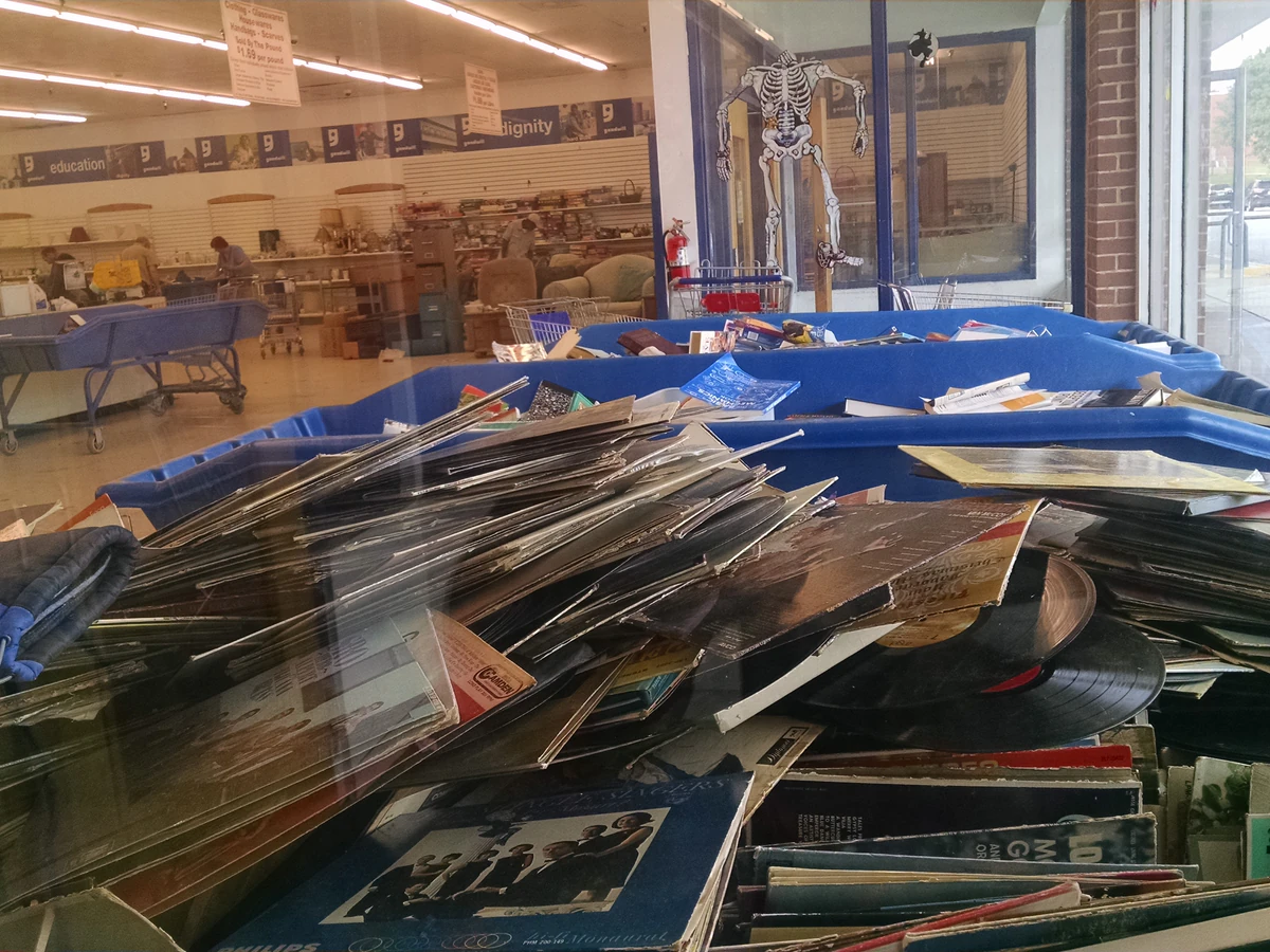 Goodwill Outlet and Donation Center in Baltimore, Maryland, featuring shoppers searching through bulk textile containers.