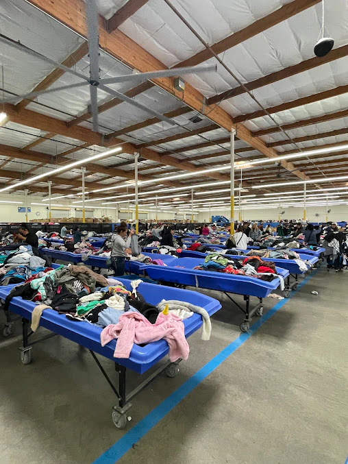 Goodwill Outlet Center and Donation Center, a Goodwill outlet store featuring shoppers searching through bulk textile contai.