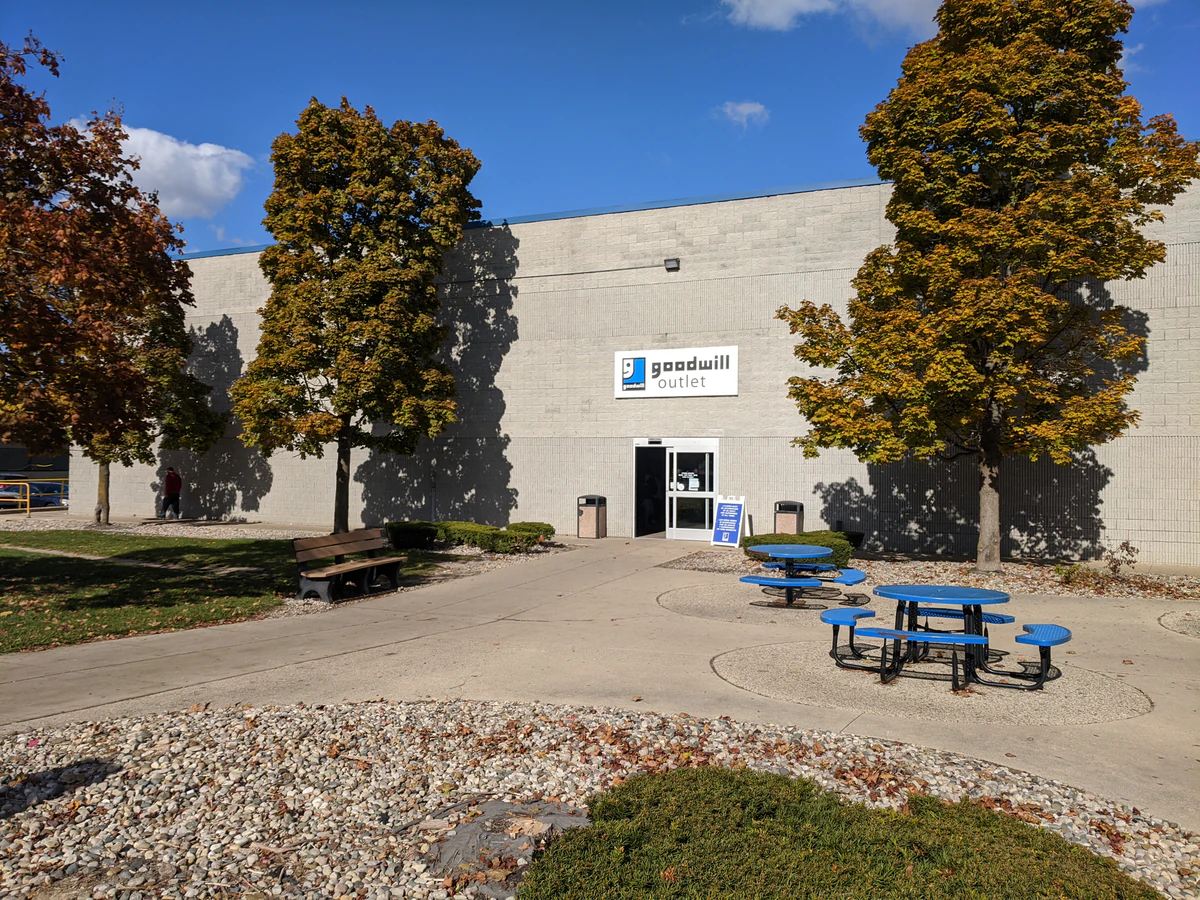 Goodwill Outlet Center in Grandville, Michigan, featuring shoppers searching through bulk textile containers.