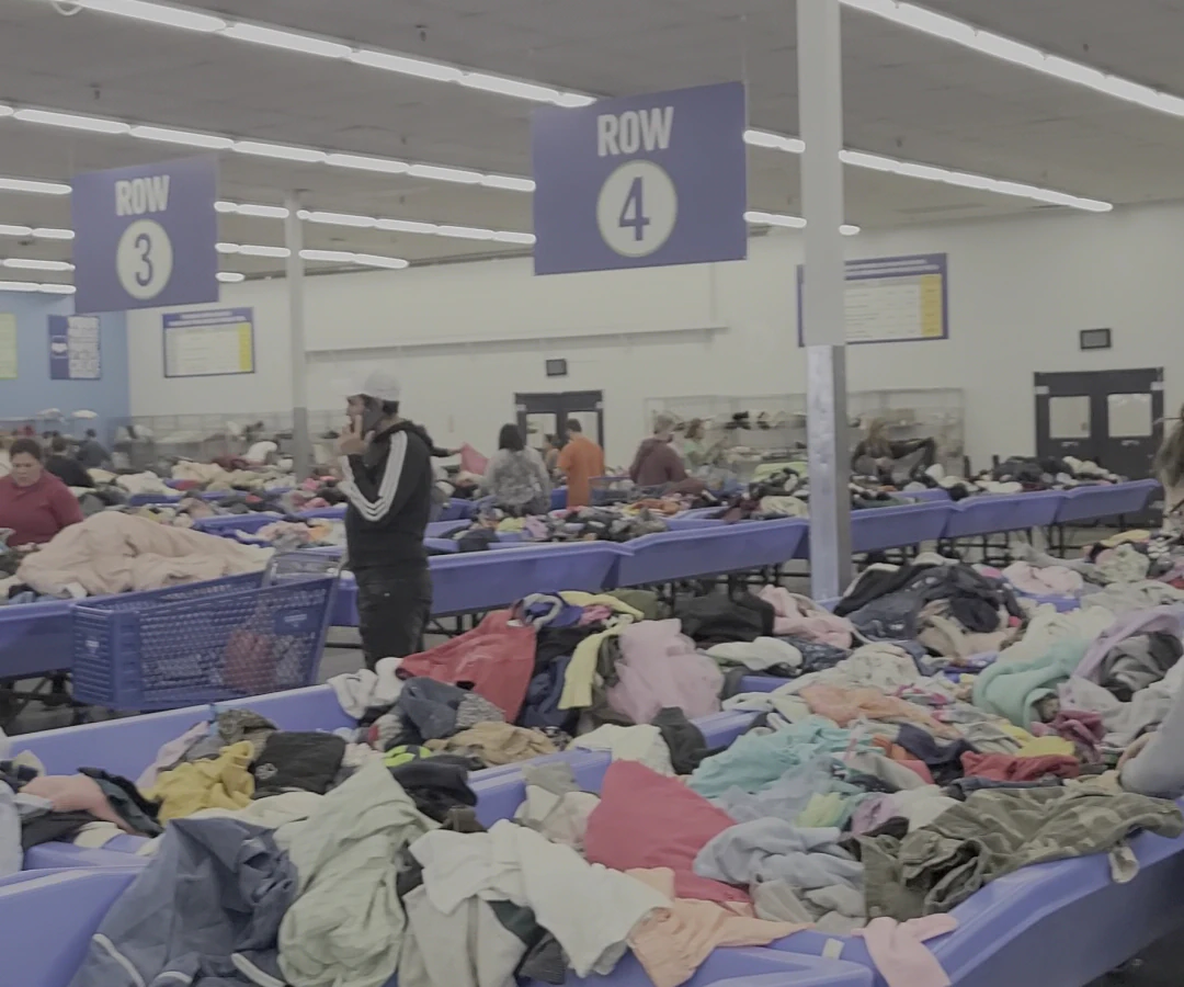 Goodwill Outlet in Louisville, Kentucky, featuring shoppers searching through bulk textile containers.