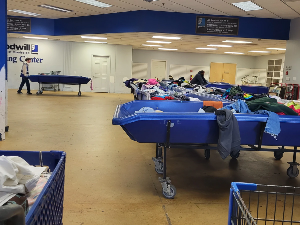 Goodwill Outlet in Hernando, Mississippi, featuring shoppers searching through bulk textile containers.