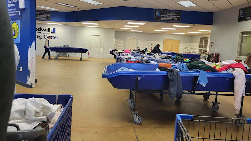 Goodwill Outlet in Hernando, Mississippi, highlighting organized racks of clothing near the checkout area.