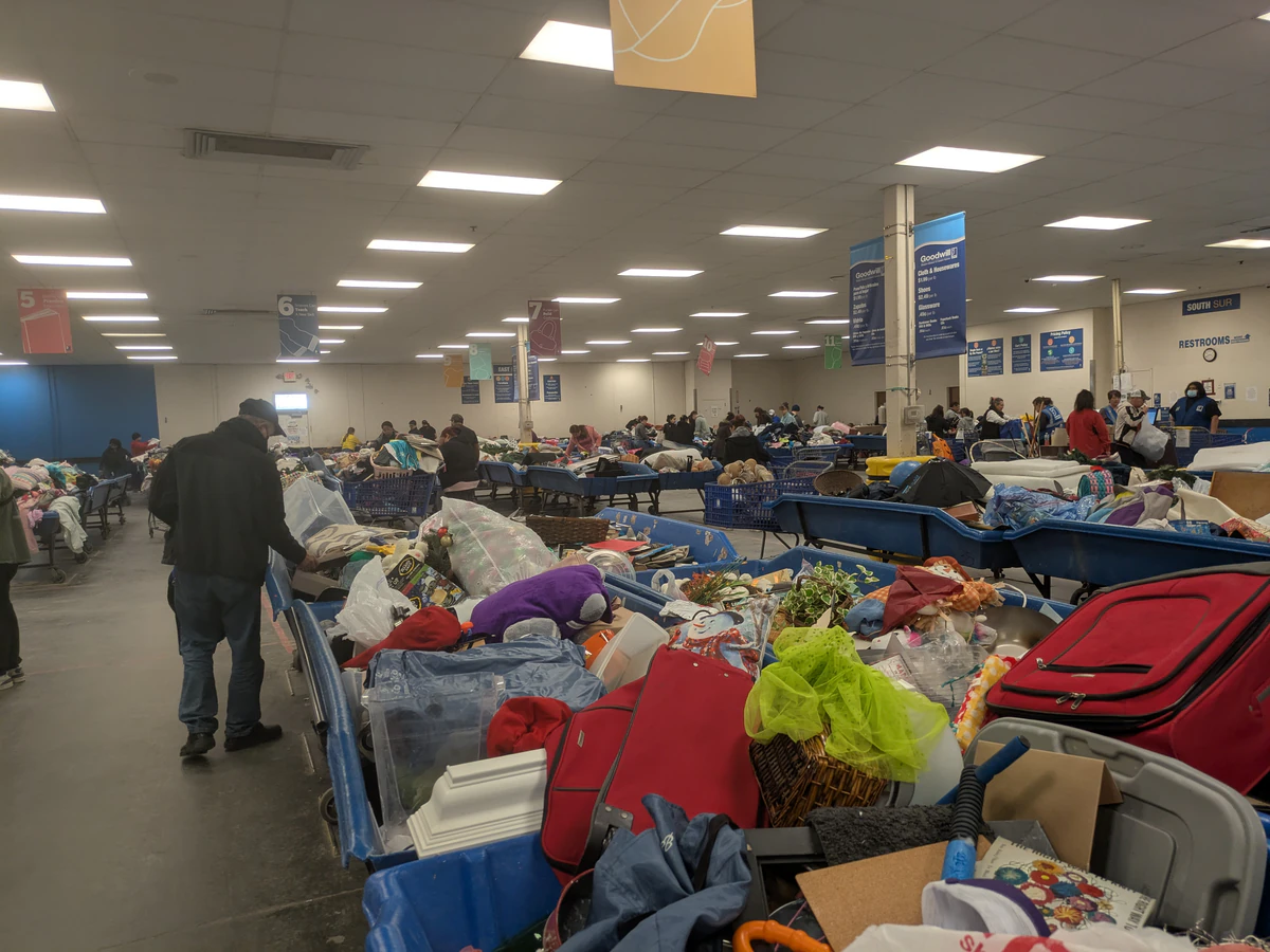 Goodwill Outlet & Recycling Center in Kansas City, Missouri, featuring shoppers searching through bulk textile containers.
