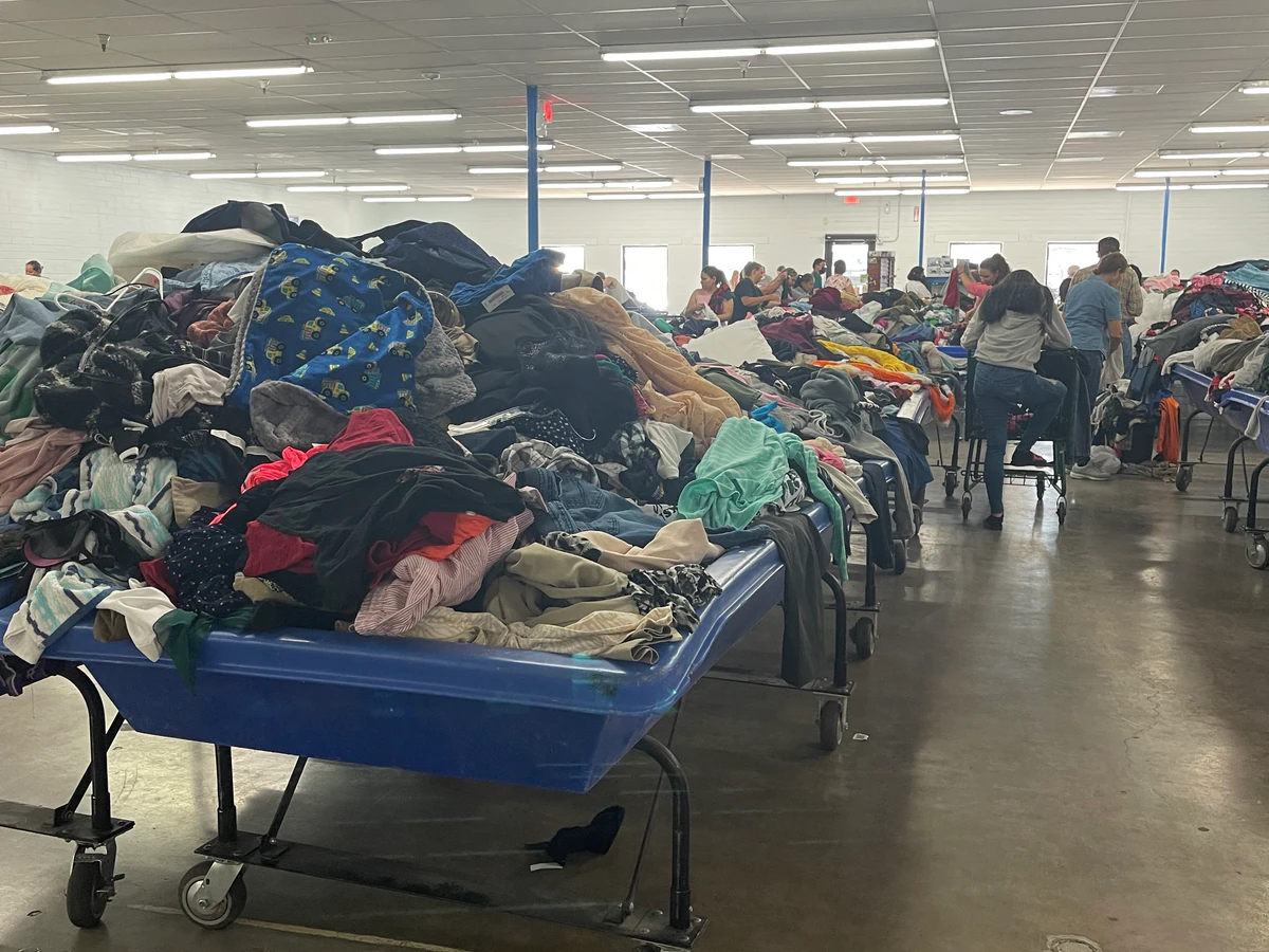 Goodwill Outlet Store and Donation Center in Nogales, Arizona, featuring shoppers searching through bulk textile containers.