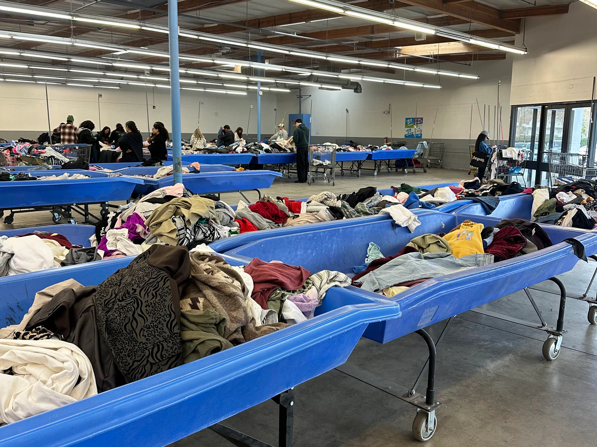 Goodwill Outlet Store in San Bernardino, California, highlighting organized racks of clothing near the checkout area.