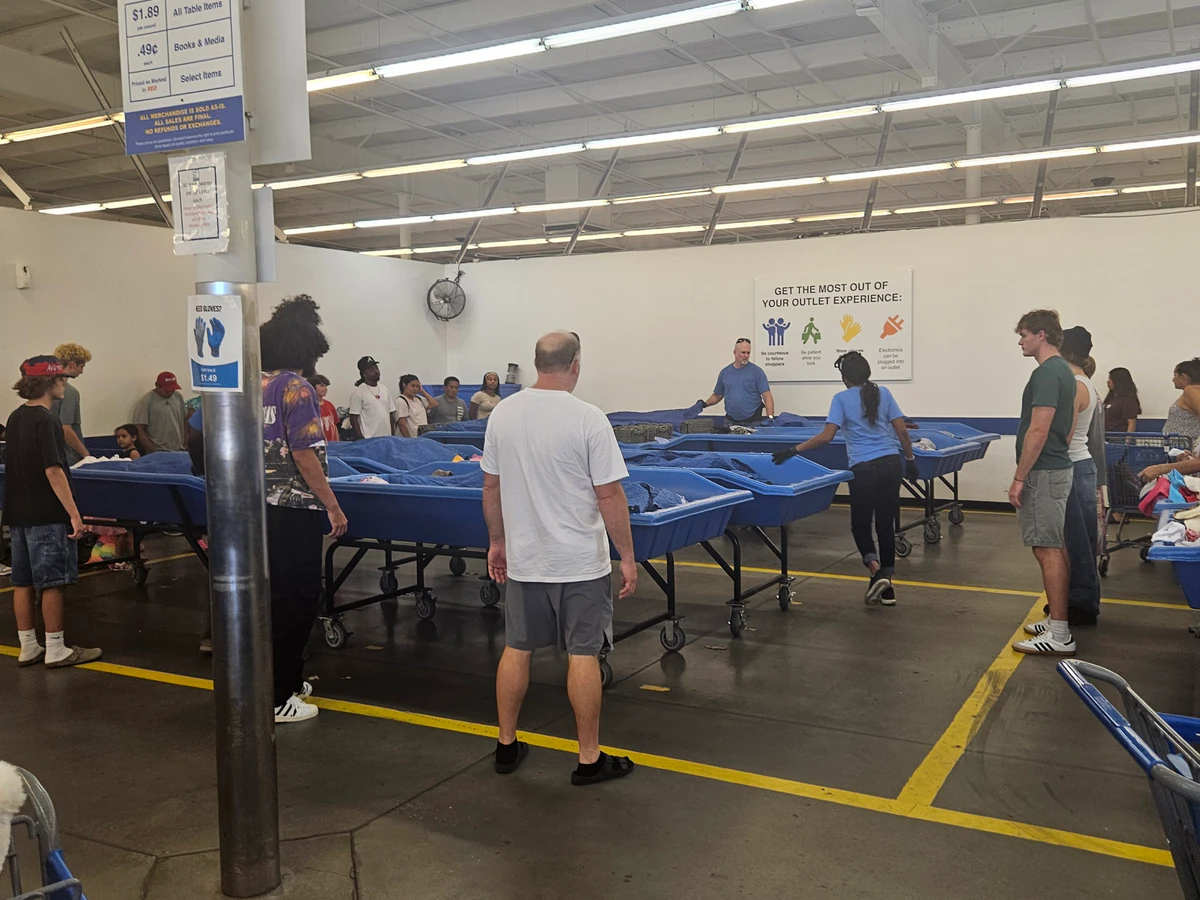 Goodwill Outlet Store in Columbus, Georgia, featuring shoppers searching through bulk textile containers.