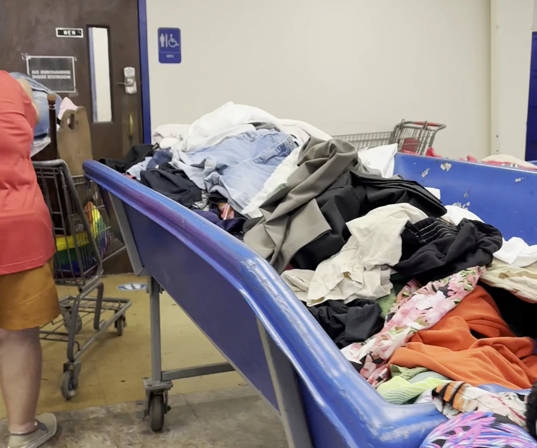 Goodwill Outlet Store in Honolulu, Hawaii, highlighting organized racks of clothing near the checkout area.