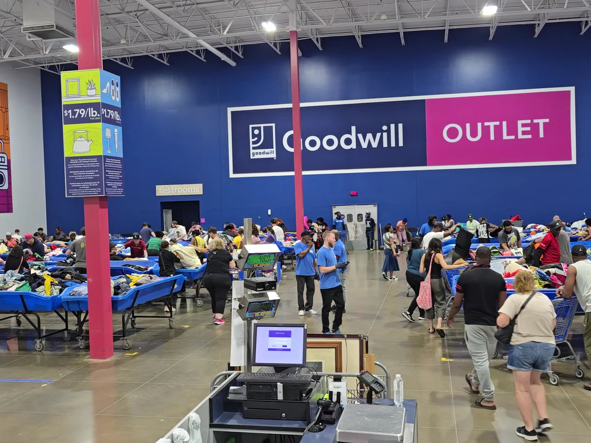 Goodwill Outlet Store in Indianapolis, Indiana, featuring shoppers searching through bulk textile containers.