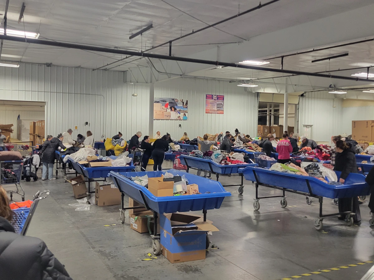 Goodwill Outlet Store in Grand Island, Nebraska, featuring shoppers searching through bulk textile containers.