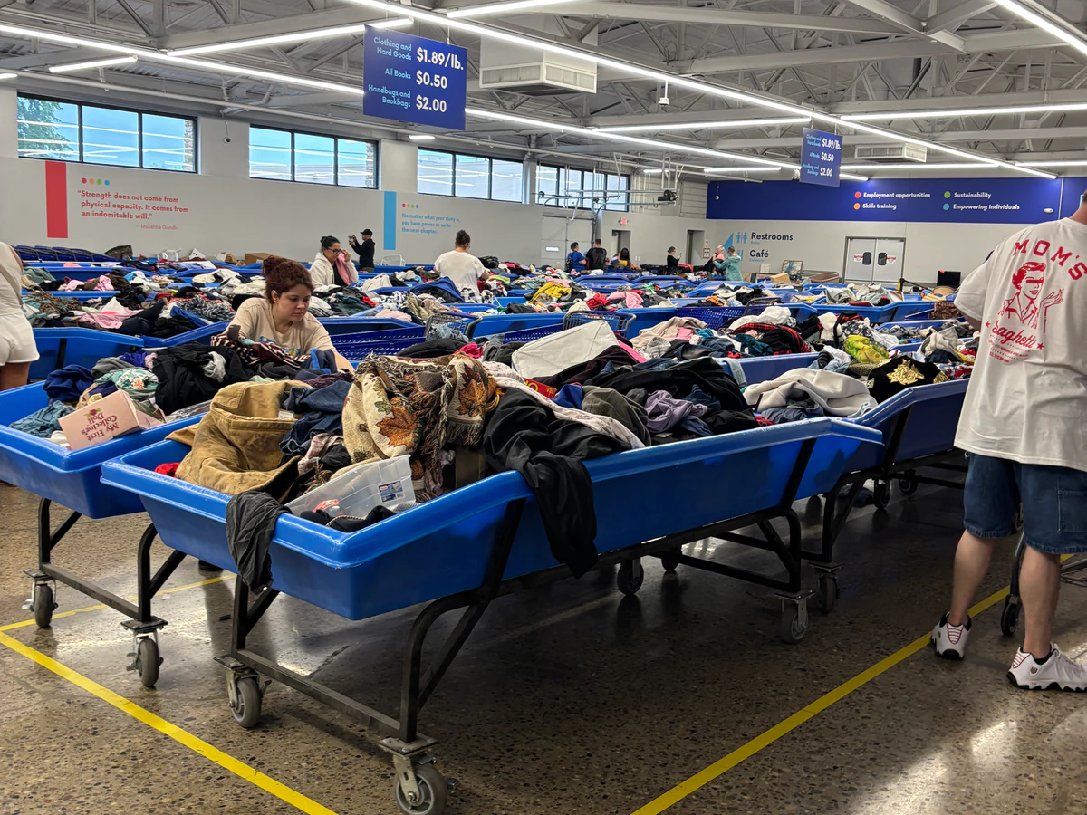 Goodwill Outlet Store in Cincinnati, Ohio, featuring shoppers searching through bulk textile containers.