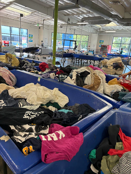 Goodwill Southern California Outlet Store, a Goodwill outlet store featuring shoppers searching through bulk textile contain.