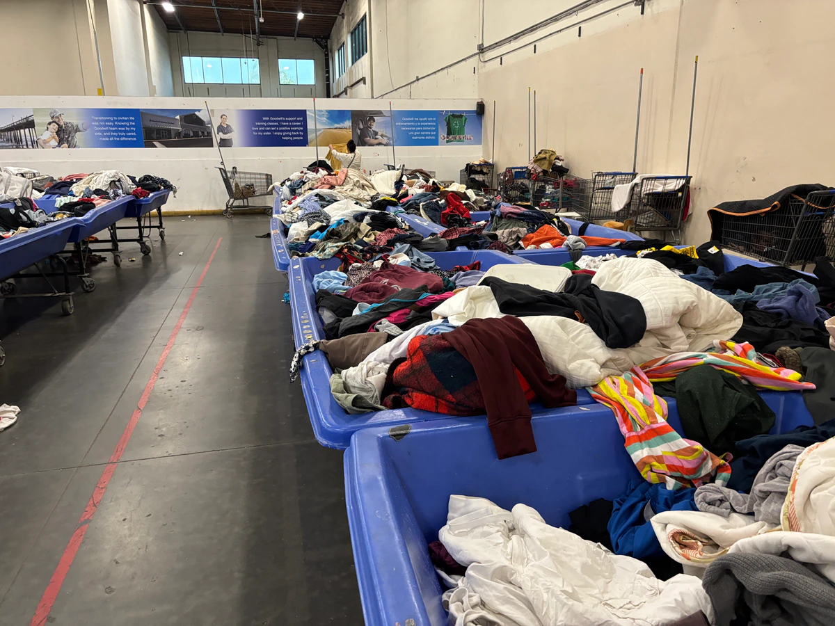 Goodwill Wholesale Outlet in Oxnard, California, highlighting organized racks of clothing near the checkout area.