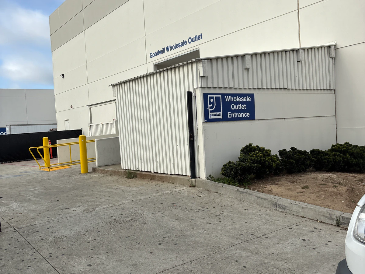 Goodwill Wholesale Outlet in Oxnard, California, showing the donation entrance and bulk pricing signage.