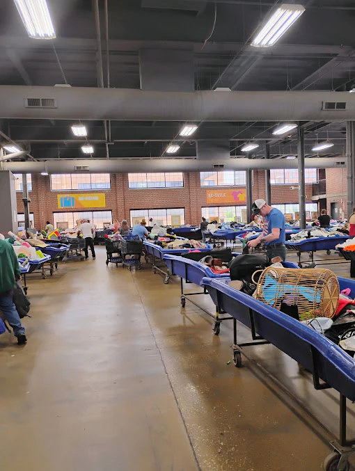 MERS Goodwill Outlet in Bridgeton, Missouri, featuring shoppers searching through bulk textile containers.