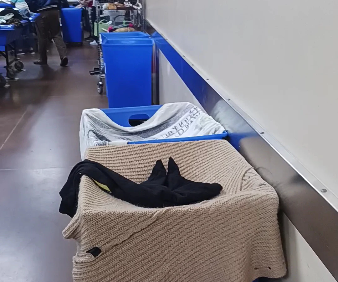 Second Editions (Goodwill Outlet) in Charlotte, North-carolina, featuring shoppers searching through bulk textile containers.